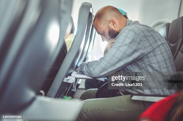 man on an airplane reading or working with tray table down - airplane tray table stock pictures, royalty-free photos & images