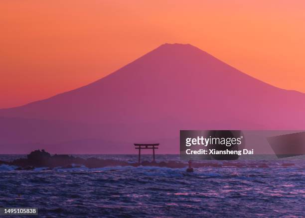 der berg fuji und die sagami-bucht bei sonnenuntergang, die farbenfrohe silhouette des berges fuji und das torii des schreins über dem shonan-meer. - präfektur kanagawa stock-fotos und bilder
