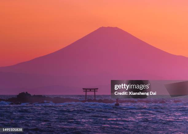 mt. fuji and sagami bay at sunset ,the colorful silhouette of mount fuji and the torii of the shrine across the shonan sea. - zushi kanagawa bildbanksfoton och bilder