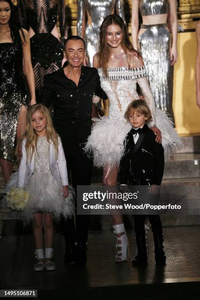 Julien Macdonald onstage at his show during London Fashion Week Autumn/Winter 2016/17, with him is a model wearing the final bridal gown, accompanied...