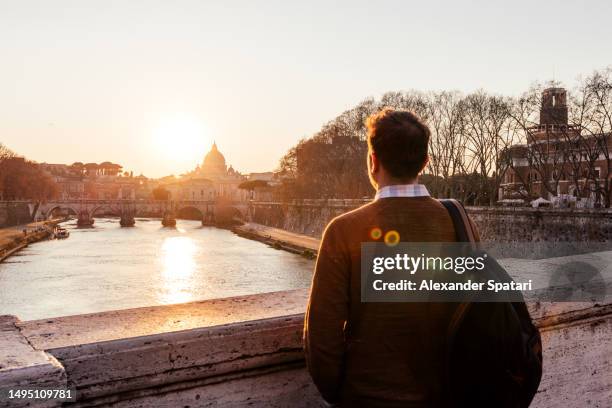 man looking at sunset in rome by tiber river, italy - stadt personen rom herbst stock-fotos und bilder