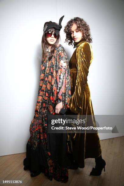 Backstage at the Preen by Thornton Bregazzi show during London Fashion Week Autumn/Winter 2016/17, one model wears a voluminous dark floral kaftan...