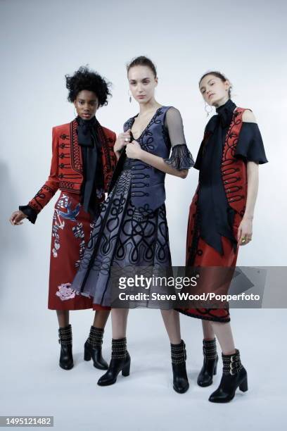 Backstage at the Temperley show during London Fashion Week Autumn/Winter 2016/17, three models weas miltary style cropped jackets and waistcoats in...