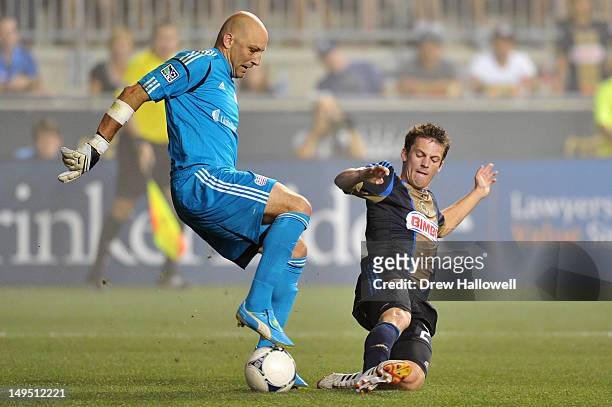 Antoine Hoppenot of the Philadelphia Union tries to steal the ball away from Matt Reis of the New England Revolution at PPL Park on July 29, 2012 in...