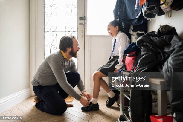 father helping daughter put on shoes in morning - habit stock pictures, royalty-free photos & images