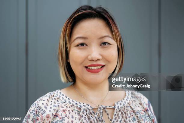 portrait of cheerful east asian woman in early 40s - two tone color stock pictures, royalty-free photos & images