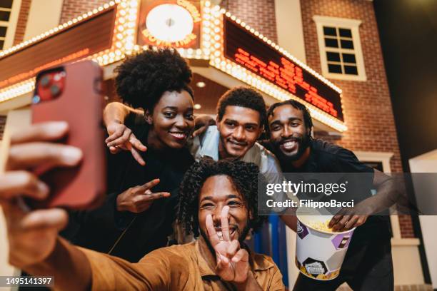 four friends are taking a selfie at the movie theatre - entrance sign stock pictures, royalty-free photos & images