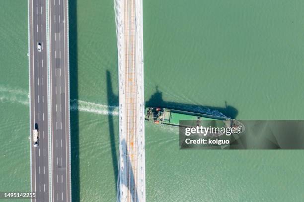 bulk ship sails under the bridge - bulk carrier stock pictures, royalty-free photos & images