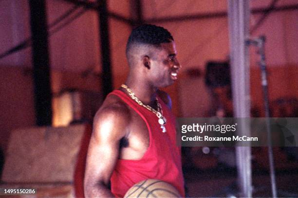 Professional NFL and MLB player Deion Sanders, on the Atlanta Braves and Atlanta Falcons teams, holds a basketball during a break from filming on a...