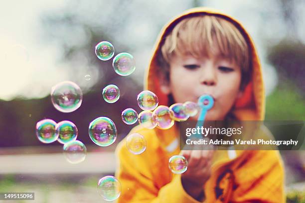 boy blowing bubbles - bubble wand foto e immagini stock