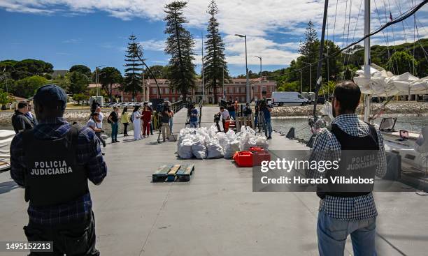 Members of the Judiciary Police stand near sacks containing cocaine while Naval Commander of the Portuguese Navy Vice-Admiral Nuno Chaves Ferreira...