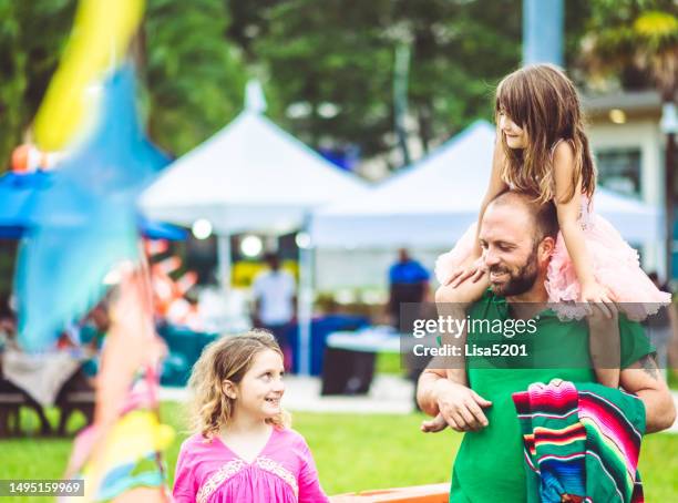 vater mit zwei kindern auf einem sommerkarnevalsfestival oder vergnügungspark im freien, familienspaß - wohltätigkeitsfest stock-fotos und bilder