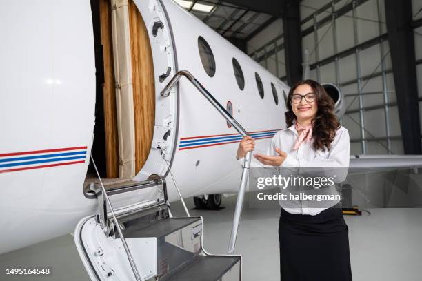 air hostess da la bienvenida al espectador al jet privado - aviacion fotografías e imágenes de stock