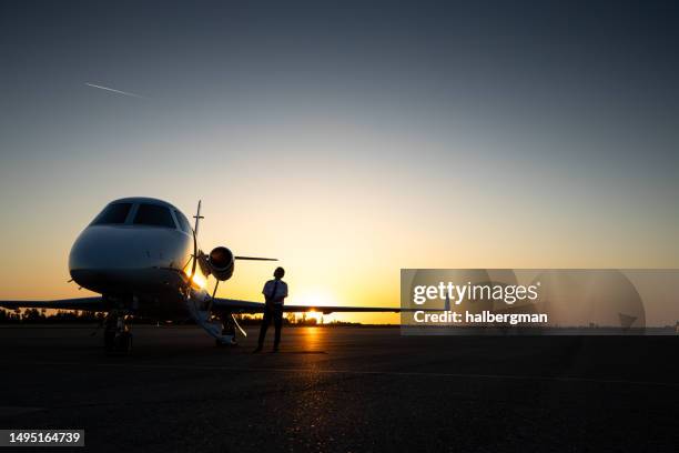 pilot looking at private jet - corporate jet stock pictures, royalty-free photos & images