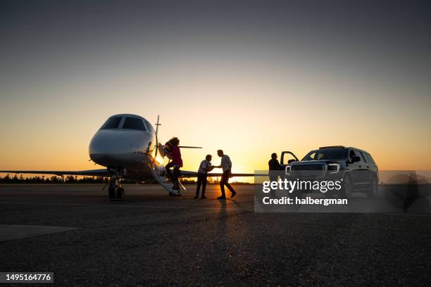 pilot welcoming passengers into private jet - private jet stockfoto's en -beelden