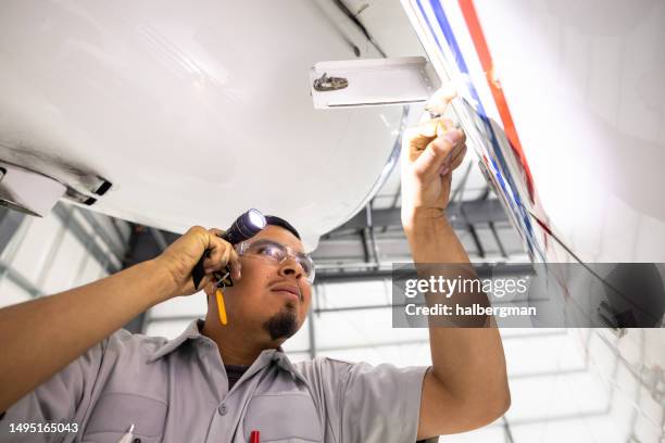 mécanique vérifiant un jet privé avec lampe de poche - aviation-générale photos et images de collection