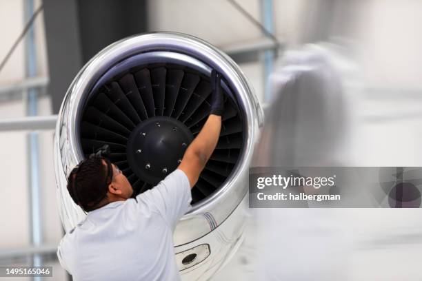 airplane mechanic checking jet engine of private plane - luchtvaartindustrie stockfoto's en -beelden