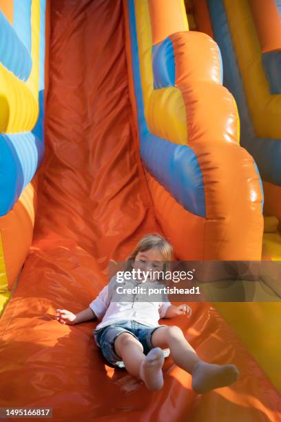 little kid having fun in inflatable castle playground - bouncy castle stock pictures, royalty-free photos & images