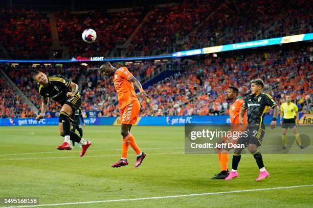 Christian Ramirez of Columbus Crew heads the ball against Obinna Nwobodo of FC Cincinnati during the second half of a MLS soccer match at TQL Stadium...