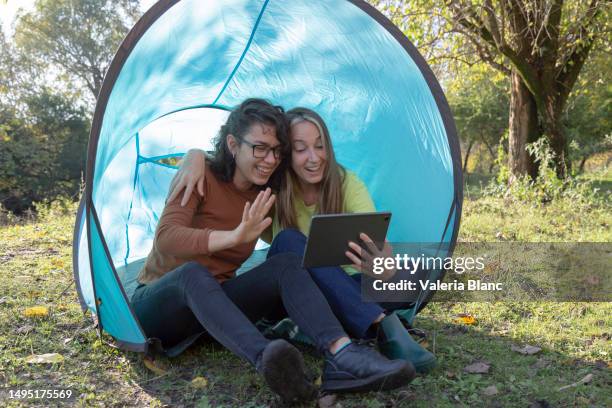 two women outdoors using a digital tablet - ipad blanc stock pictures, royalty-free photos & images