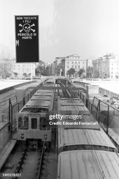 Elevated view of subway trains in the recently opened Rome Metro system, Rome, Italy, February 24, 1980. A sign above warns 'Non toccate i fili;...