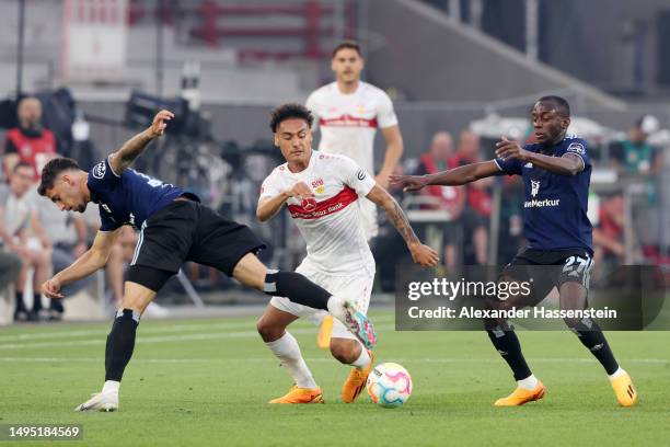 Enzo Millot of VfB Stuttgart is challenged by Ludovit Reis and Jean-Luc Dompe of Hamburger SV during the Bundesliga playoffs first leg match between...