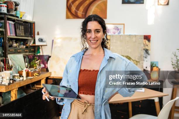 portrait of a mid adult woman painting/drawing with a digital tablet at home - creative space stock pictures, royalty-free photos & images