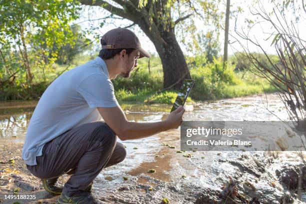 man by the stream with digital tablet - ipad blanc stock pictures, royalty-free photos & images