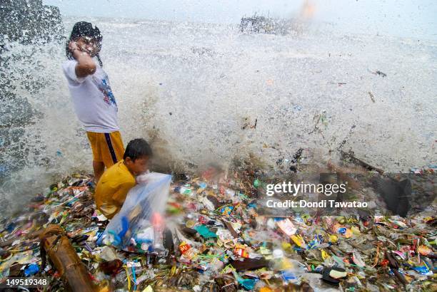 Children sift through debris in search of recyclable materials in the coastal town of Navotas on July 30, 2012 in Manila, Philippines. Heavy rains...