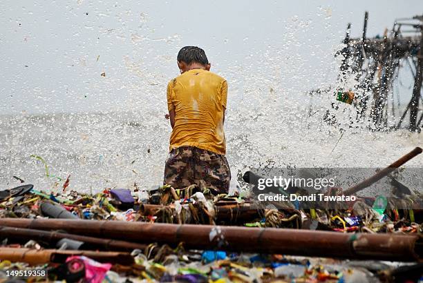 Child sifts through debris in search of recyclable materials in the coastal town of Navotas on July 30, 2012 in Manila, Philippines. Heavy rains and...