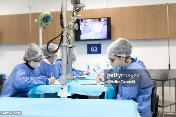 medical students taking notes on how to perform an autopsy in class - female autopsy bildbanksfoton och bilder