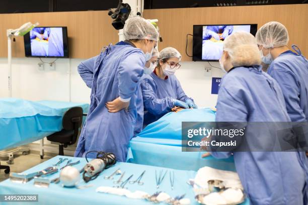 medical students learning how to perform an autopsy during practical class - medische procedure stockfoto's en -beelden