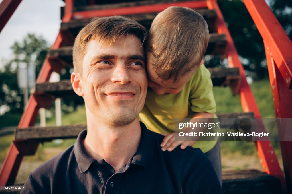 Portrait of a happy family of dad and son. son hugging dad