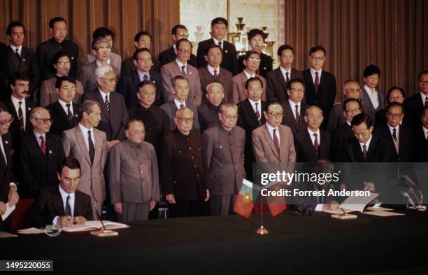Surrounded by various officials, Portuguese Prime Minister Anibal Cavaco Silva and Chinese Premier Zhao Ziyang sign a joint resolution, Beijing,...