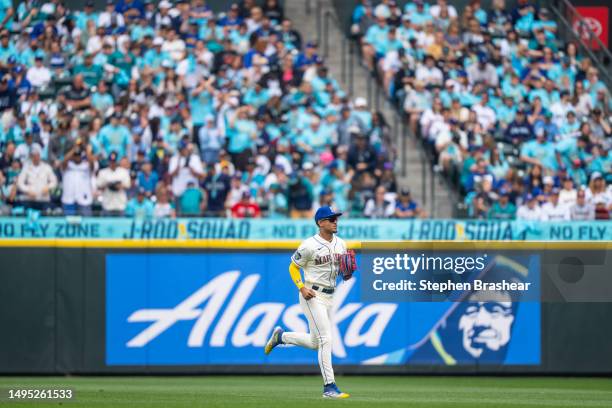 Centerfielder Julio Rodriguez of the Seattle Mariners jogs off the field in front of a section fans dedicated to him during a game against the...