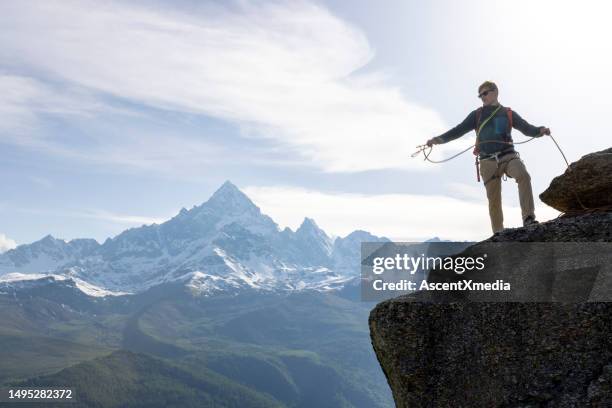 mountain climber prepares rope on mountain summit - 爬山繩 個照片及圖片檔