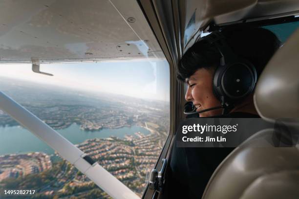 a young boy sits on the airplane - werk in uitvoering stockfoto's en -beelden