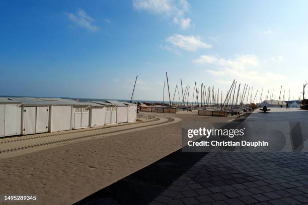 row of white beach huts on a beach against blue sky - centre d'intérêt foto e immagini stock