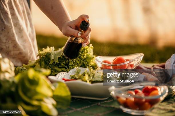 adding olive oil on the salad - condiment stock pictures, royalty-free photos & images