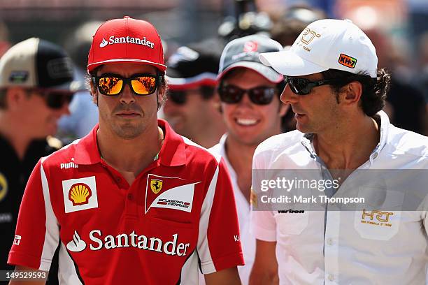 Fernando Alonso of Spain and Ferrari and Pedro de la Rosa of Spain and Hispania Racing Team attend the drivers parade before the Hungarian Formula...