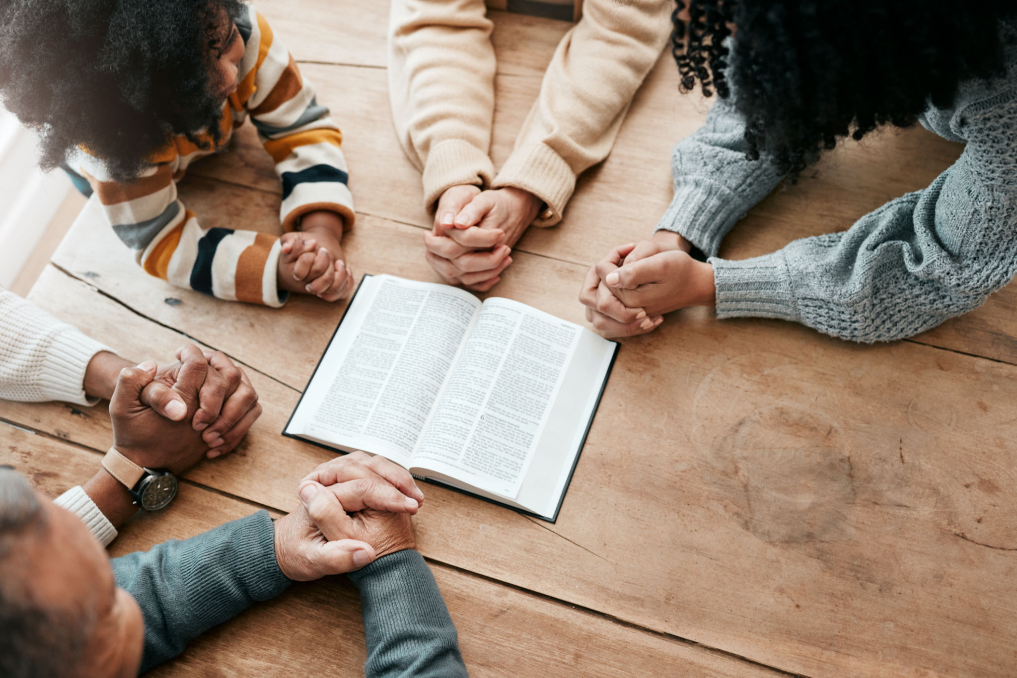 Bible, reading book or hands of family in prayer, support or hope in Christianity home for worship together. Mother, father or grandparents studying, praying or learning God in religion with children Bible, reading book or hands of family in prayer, support or hope in Christianity home for worship together. Mother, father or grandparents studying, praying or learning God in religion with children