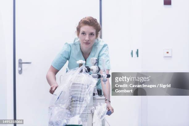 nurse pushing portable respiratory device - hospital ventilator stock pictures, royalty-free photos & images