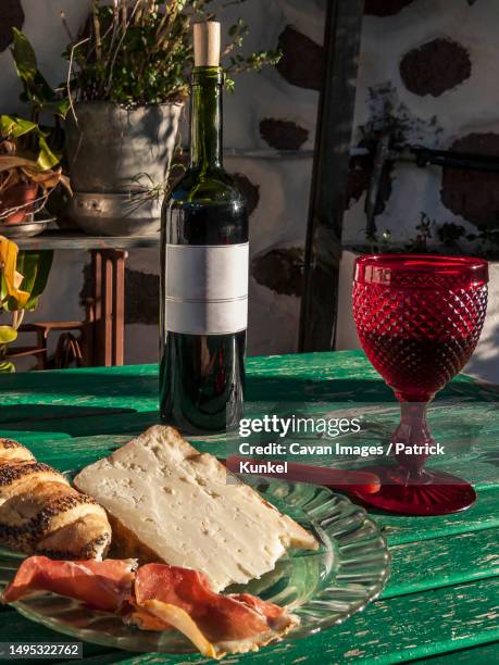 red wine, jam and goat cheese on green wooden table - tejeda stock pictures, royalty-free photos & images