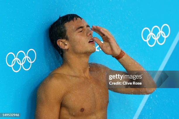 Tom Daley of Great Britain stands under a pool deck shower during the Men's Synchronised 10m Platform Diving on Day 3 of the London 2012 Olympic...