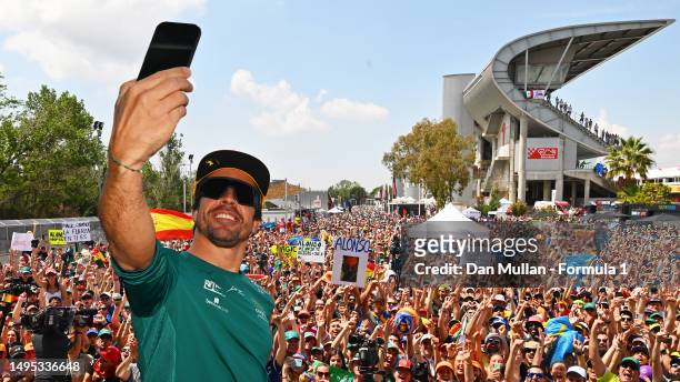 Fernando Alonso of Spain and Aston Martin F1 Team takes a photo from the fan stage prior to practice ahead of the F1 Grand Prix of Spain at Circuit...
