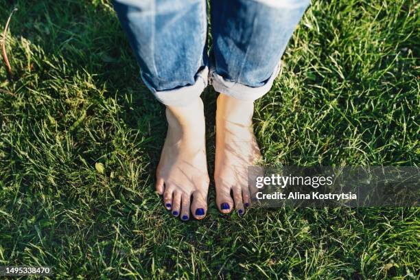 pedicure with blue nails on green lawn - teen stockfoto's en -beelden