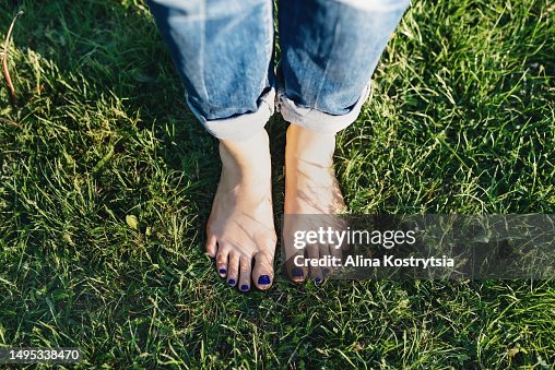 Pedicure with blue nails on green lawn