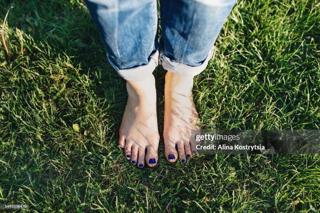 Pedicure with blue nails on green lawn