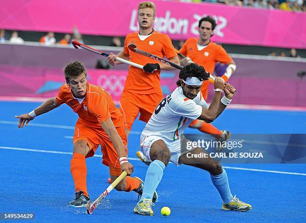 Netherland's Sander de Wijn vies with India's Shivendra Singh during their London 2012 olympic hockey match at the Riverbank venue in the Olympic...
