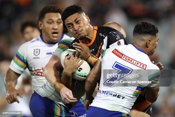 Junior Tupou of the Tigers is tackled during the round 14 NRL match between Wests Tigers and Canberra Raiders at Campbelltown Stadium on June 02,...